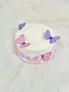 a white cake with pink and purple butterflies on it