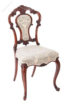 an ornate wooden chair with white fabric on the back and seat, against a white background