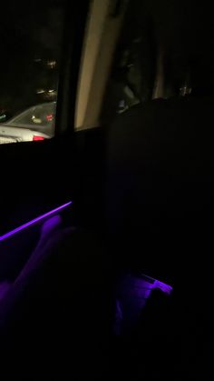 the interior of a car is lit up with purple lights