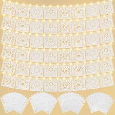 white paper doidles with string lights and hearts on the top, in front of a yellow background