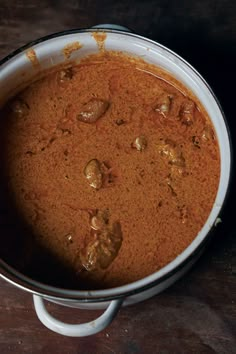 a pot filled with food sitting on top of a wooden table