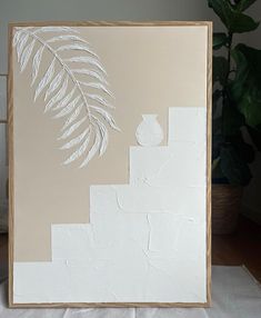 a painting with white paint and a plant in the background