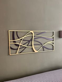 a metal sculpture on the wall above a bed