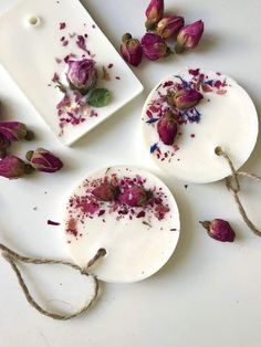 three soaps with dried flowers on them sitting next to each other and tied in twine