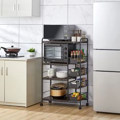 a kitchen with a microwave and refrigerator next to a stove top oven in the corner