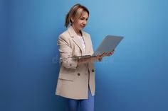 Mobile blond young woman freelancer in a jacket with a laptop on the background of the studio stock photography Network Technology, Laptop Backgrounds, A Jacket, Photography Studio, Young Woman, The Studio