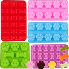 four dog paw shaped ice trays in different colors and sizes, each with paws on them