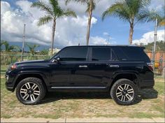 a black suv parked in front of some palm trees