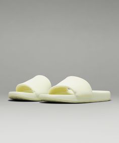 a pair of white slippers sitting on top of a gray floor next to each other