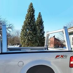 the back end of a white truck parked in front of a house