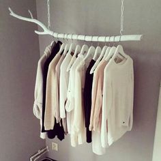 several sweaters are hanging on a clothes rack