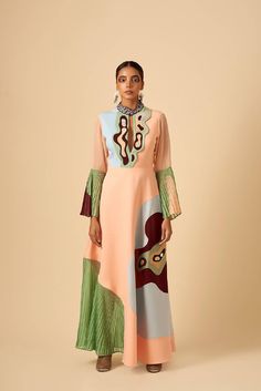 This timeless silhouette dress portrays the breath of spring summer freshness. Valley of blush, our go-to outfit with flared sleeves and high collar; deep plunge neckline. Vale of soft hues, delicately pleated georgette and embroidery details creates a sense of grace and sophistication. Back zip closure. Shell: Poly Crepe, IndiaShell: Poly Georgette, IndiaShell: Fauxe Suede, IndiaLining: Poly Rayon, India Made in IndiaDry-clean onlyModel is wearing UK 8, Height 179cm Blush Gown, Dresses By Pattern, Silhouette Dress, Pink Gowns, Deep Plunge, Gowns Online, Indian Fashion Designers, Plunge Neckline, Dress Silhouette