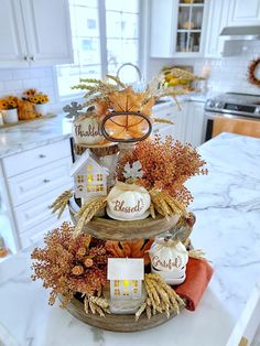 a three tiered tray filled with fall decorations