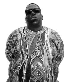 a black and white photo of a man with sunglasses on his head, wearing a patterned shirt