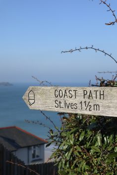 a wooden sign pointing in opposite directions to the coast