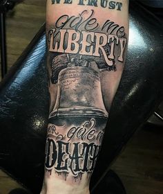 a person with a tattoo on their leg that reads we trust the liberty and is holding a bell