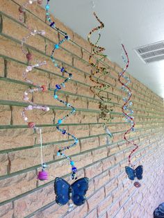 a brick wall with butterflies on it and streamers hanging from the bricks in front of it