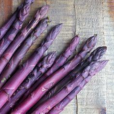 purple asparagus sitting on top of a wooden table