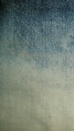 the back side of a pair of jeans with faded blue and white paint on them