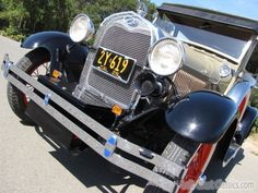 an antique car is parked on the side of the road