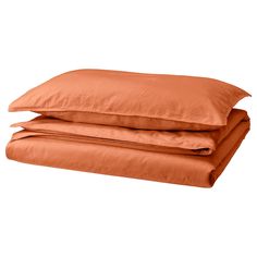 two orange pillows stacked on top of each other