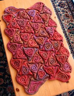 a wooden table topped with an intricately designed rug