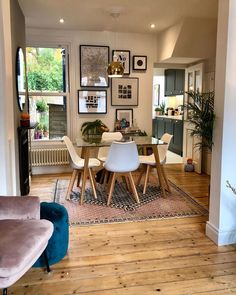 a dining room table with chairs and pictures on the wall