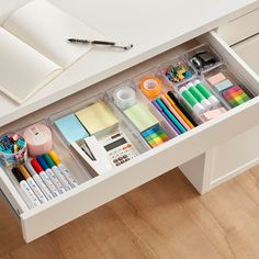 an organized drawer with pens, markers, pencils and other office supplies on it