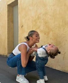 a woman is playing with her child on the street