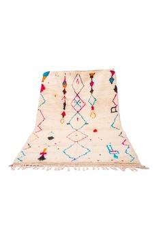 a white rug with multicolored designs and fringes on the bottom, against a white background