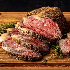 some meat is on a cutting board with herbs and seasoning next to the meat