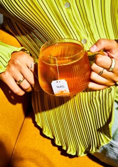 a woman holding a cup with a tag on it