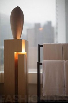 a candle that is sitting on top of some blocks in front of a window with cityscape behind it