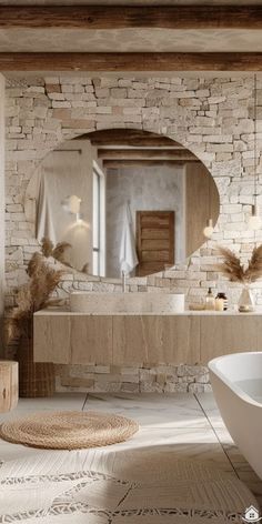 a white bath tub sitting next to a bathroom sink under a large round mirror on the wall