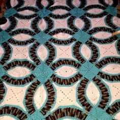 a blue and white crocheted blanket with circles on it