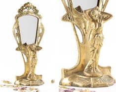 an ornately decorated gold mirror and vase with flowers on the ground next to it