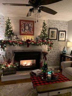 a living room decorated for christmas with lights and decorations on the fireplace mantels