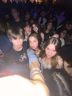 a group of young people sitting next to each other in front of a crowd at a concert