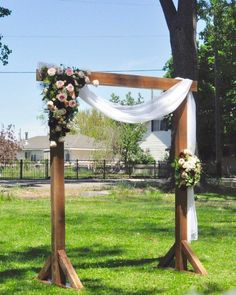 an outdoor ceremony setup with flowers and white draping