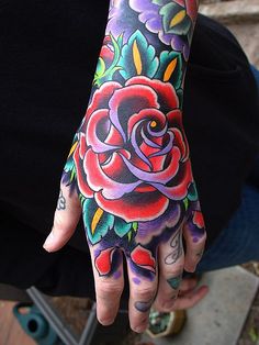 a person's hand with a tattoo on it and a rose in the middle