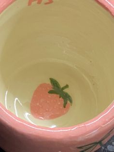 a pink bowl with a strawberry painted on it