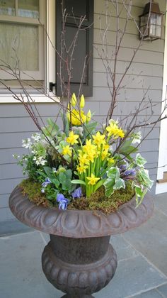 a potted planter with flowers and plants in it on the front porch area