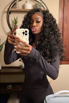 a woman taking a selfie with her cell phone in front of her face and wearing a black bodysuit