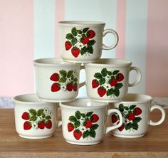 six white cups with strawberries painted on them