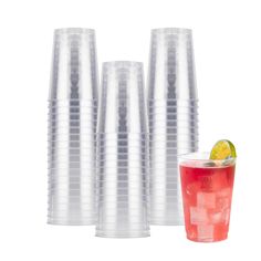 four plastic cups with different types of drinks in them and one has a slice of lime on the rim