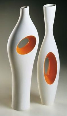 two white and orange vases sitting next to each other