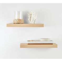 two wooden shelves with bowls and candles on them