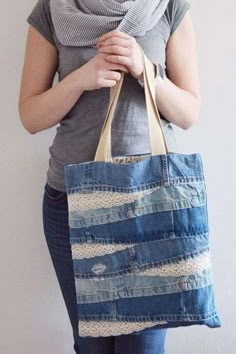 a woman is holding a bag made out of old jeans