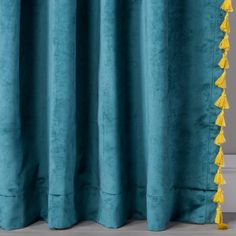 a blue curtain with yellow tassels on it