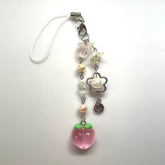 a key chain with an apple charm hanging from it's side on a white surface